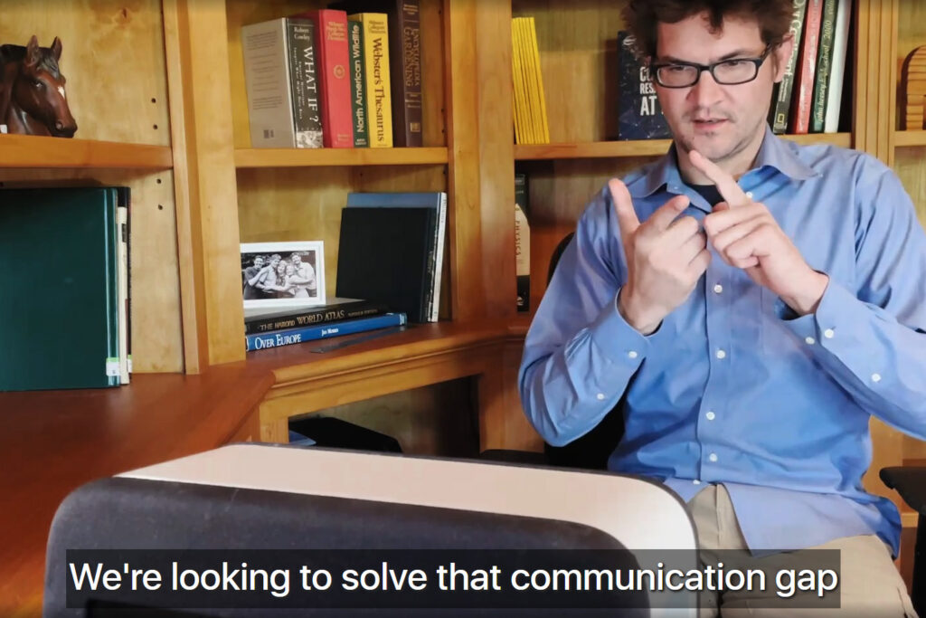 Screen capture from video of Adam Munder with caption "We're looking to solve that communication gap"